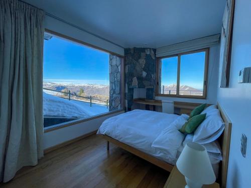 a bedroom with a bed and a large window at Casa Farellones in Farellones