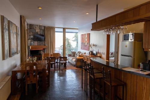 a kitchen and living room with a bar and dining room at Casa Farellones in Farellones