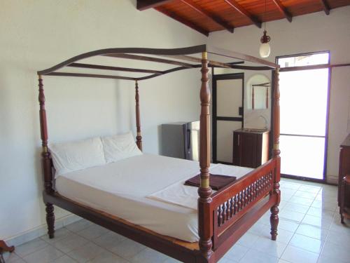 a bedroom with a wooden bed with a wooden frame at Horton Studios in Colombo