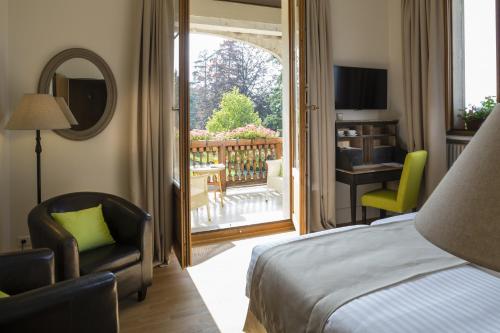 a hotel room with a bed and a sliding glass door at Le Manoir du Golf in Publier
