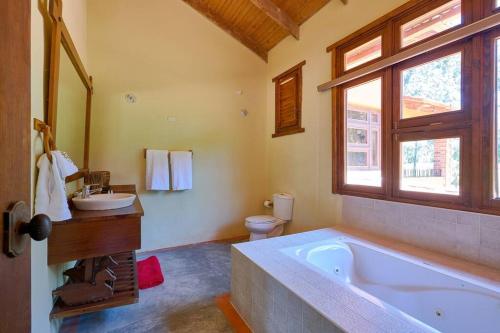 ein Badezimmer mit einer Badewanne, einem Waschbecken und einem WC in der Unterkunft Fantastic Harmony Chalet in Pinar del Sol in Jarabacoa