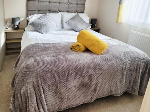 a bedroom with a bed with a yellow towel on it at Nightingale in South Cerney