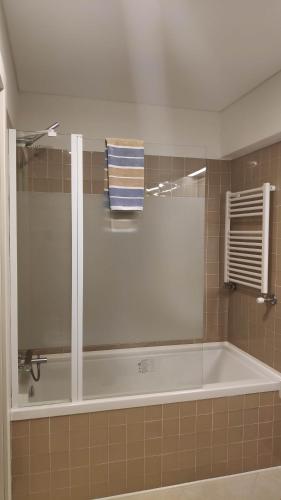 uma banheira na casa de banho com uma toalha em Trindade Apartment em Porto