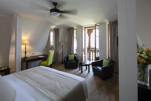 ein Hotelzimmer mit einem Bett und zwei Stühlen in der Unterkunft Le Manoir du Golf in Publier