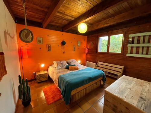 a bedroom with a bed in a wooden room at L'Hacienda de la plaine in Le Tampon