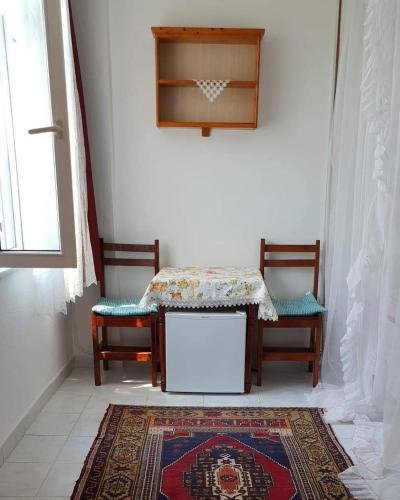 a room with two chairs and a table and a rug at Akay Hotel in Patara
