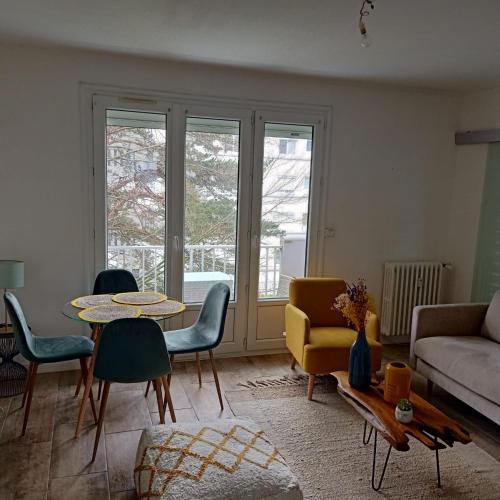 un salon avec un canapé, une table et des chaises dans l'établissement Beau T3 60m2 très cosy proche du centre ville, à Saint-Jacques