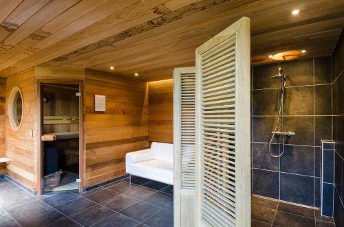 a bathroom with a bath tub and a shower at Wellnessvakantiehuis Victorello in Heuvelland