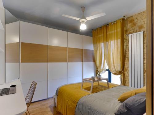 um quarto com uma cama e uma secretária com um computador portátil em Mediolanum Forum-Milano Sud Area-Free Parking & Wi-Fi em Buccinasco