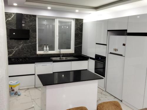 a white kitchen with a sink and a refrigerator at Antonelya Home in Sapanca