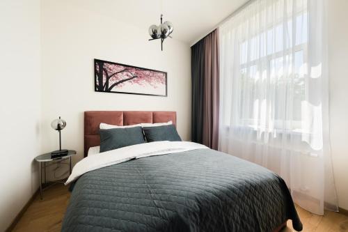 a bedroom with a bed and a window at West In Apartment in Liepāja