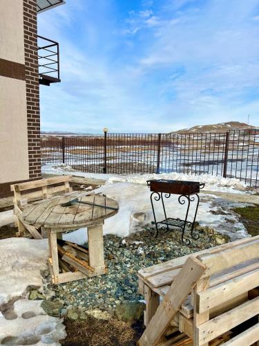 a patio with a picnic table and a bench at Lake View in Borovoye