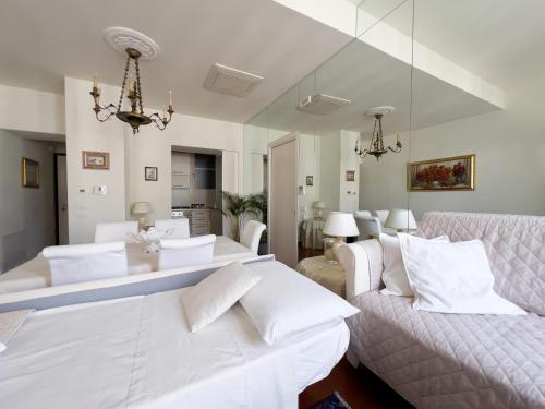 una sala de estar con muebles blancos y una lámpara de araña. en Trieste Luca's Home, en Trieste