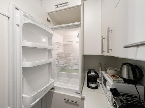 a white kitchen with an open refrigerator at Trieste Luca's Home in Trieste