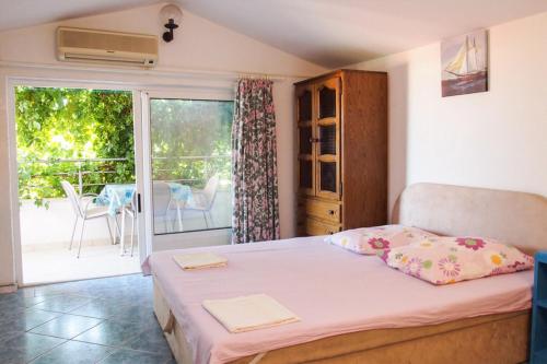 a bedroom with a bed and a balcony at Apartments Pomalo in Makarska