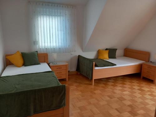 a bedroom with two beds and a window at Ferienhaus Carolin in Heidenheim an der Brenz