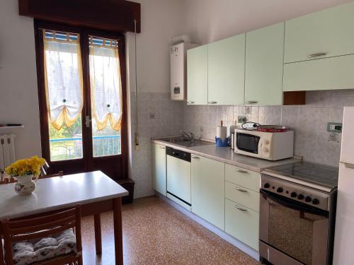 a kitchen with white cabinets and a microwave at Appartamenti Ancora Azzurra in Deiva Marina