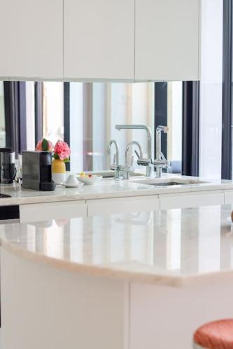 a white kitchen with two sinks and a counter at T'Luz in Porto
