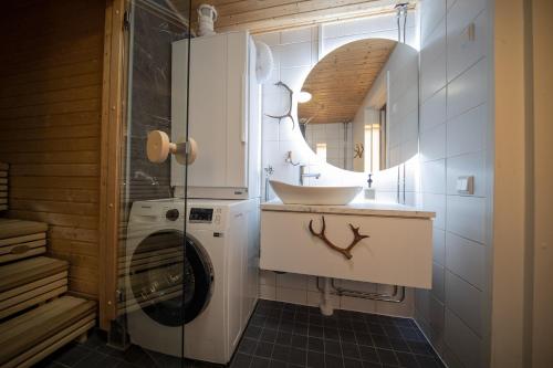 a bathroom with a sink and a washing machine at Tunturihuoneisto LAAKEUS in Syöte