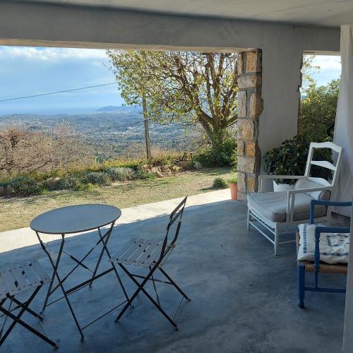 Appartement cosy vue mer في Magagnosc: طاولة وكراسي على شرفة مطلة