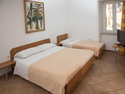 a hotel room with two beds and a television at Jazz Apartments in Piran