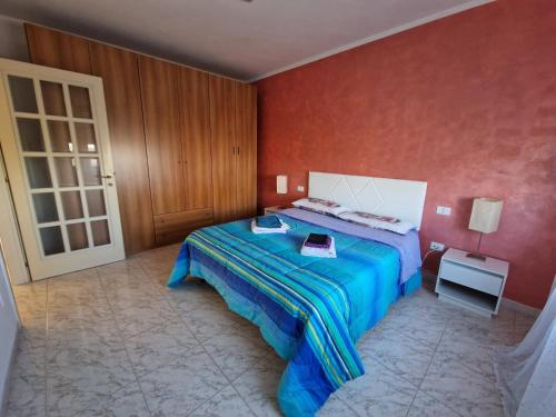 1 dormitorio con cama y pared roja en Appartamento Divino Tramonto, en Altedo