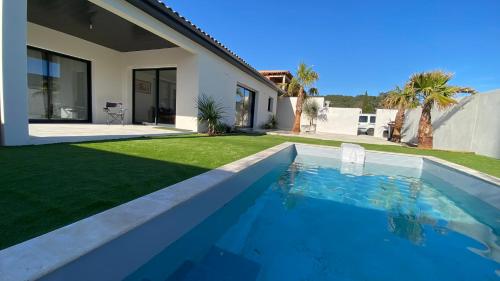une piscine dans l'arrière-cour d'une maison dans l'établissement Villa Palma, à Lignan-sur-Orb