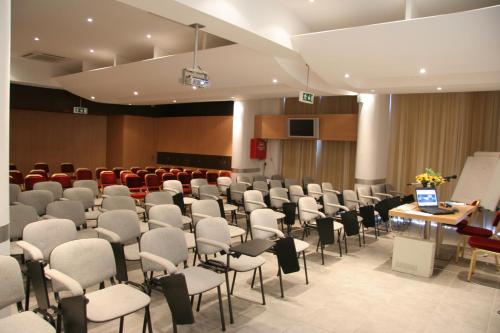 a conference room with chairs and a podium in the middle at Spetses Hotel in Spetses