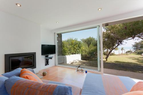 a living room with a couch and a large window at Playa de Muro - Nordvillas in Muro