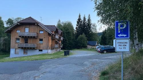 a sign on the side of a road with a building at Apartmán Kovárna in Prášily