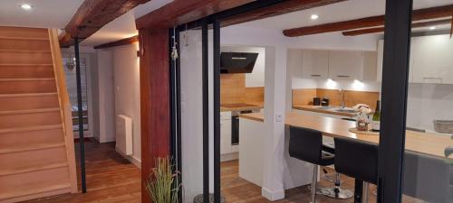 une cuisine avec des armoires blanches et un comptoir dans l'établissement Villé centre - Gîte Le Villois - Au coeur de l'Alsace, à Villé