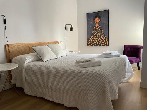 a bedroom with a bed and a painting of a woman at Contemplando la Catedral by Exclusive Burgos Apartments in Burgos
