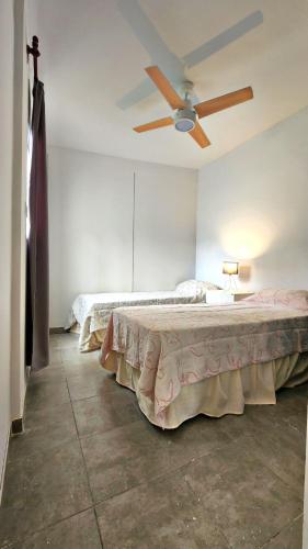 sypialnia z łóżkiem i wentylatorem sufitowym w obiekcie COMPLEJO AVIV w mieście La Rioja