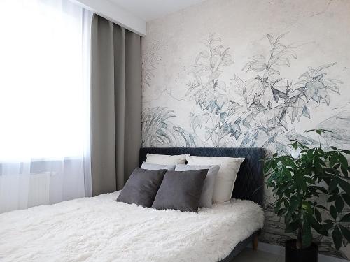 a bedroom with a bed with a large painting on the wall at Apartament Kraszewskiego in Białystok