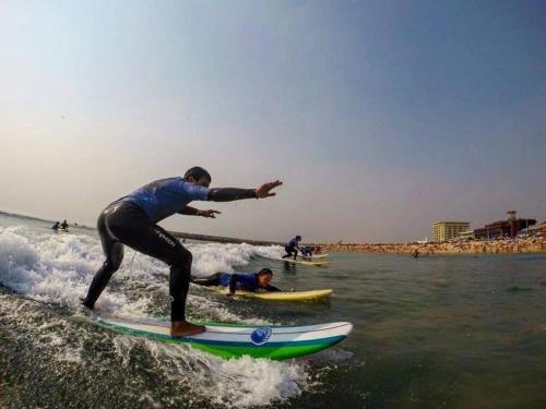 a man riding a wave on a surfboard in the ocean at Casa de Férias_As Oliveiras II in Espinho