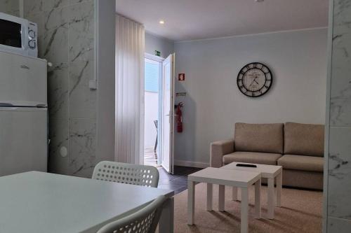 uma cozinha e sala de estar com um sofá e uma mesa em Casa de Férias_As Oliveiras II em Espinho