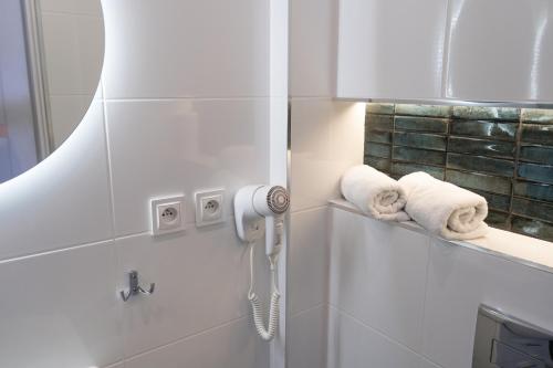 a bathroom with towels and a phone on the wall at Konik Morski in Jastarnia