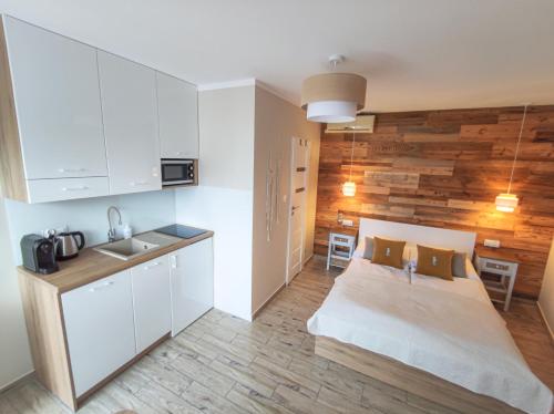 a small room with a bed and a kitchen at Konik Morski in Jastarnia