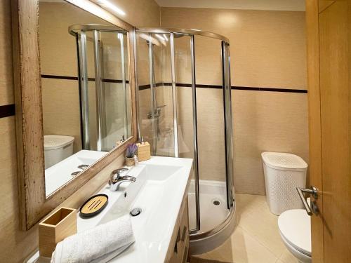 a bathroom with a sink and a shower at Sunset Lagos Apartment in Lagos