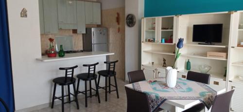 a kitchen with a table and chairs in a room at Holiday Home Tropicana in Mascali