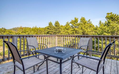 a blue table and chairs on a deck at Pelicans Watch - Meredith Lodging in Pacific City