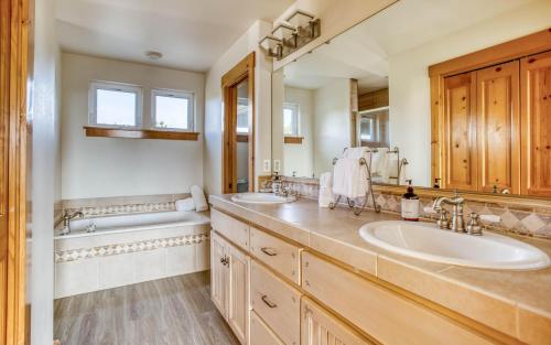 a bathroom with two sinks and a tub and a tubermottermott at Pelicans Watch - Meredith Lodging in Pacific City