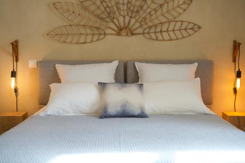 um quarto com uma cama com duas almofadas em Aux coeurs du Méjean 