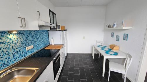 a kitchen with a sink and a table with chairs at Appartement Vanille, Ferienwohnung mit eigenem Eingang, wie ein kleines Haus in Bad Salzuflen