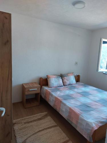 um quarto com uma cama e uma mesa de cabeceira em Goran apartmani em Sokobanja
