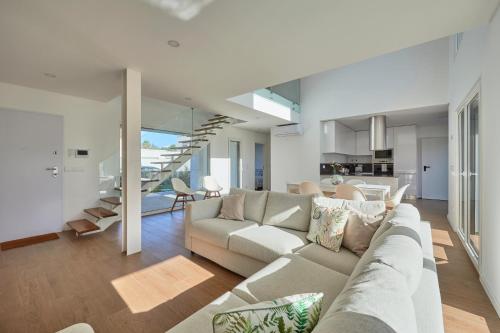 a living room with a couch and a dining room at Aroeira Villa w/ Pool near Beach, By TimeCooler in Aroeira