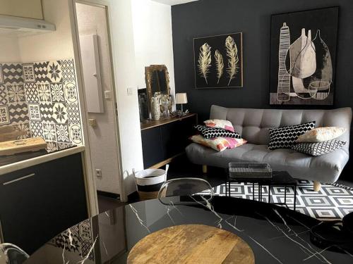 una sala de estar con un sofá y una mesa en Le Chic, en Lourdes