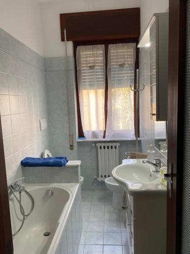 un bagno bianco con vasca e lavandino di Appartamenti Ancora Azzurra a Deiva Marina