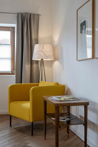 a living room with a yellow couch and a table at Gasthaus Unterwirt in Fridolfing