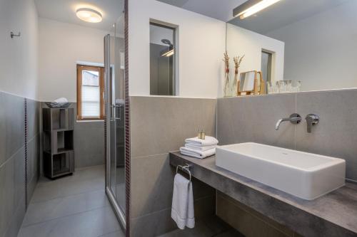 een badkamer met een wastafel en een douche bij Gasthaus Unterwirt in Fridolfing